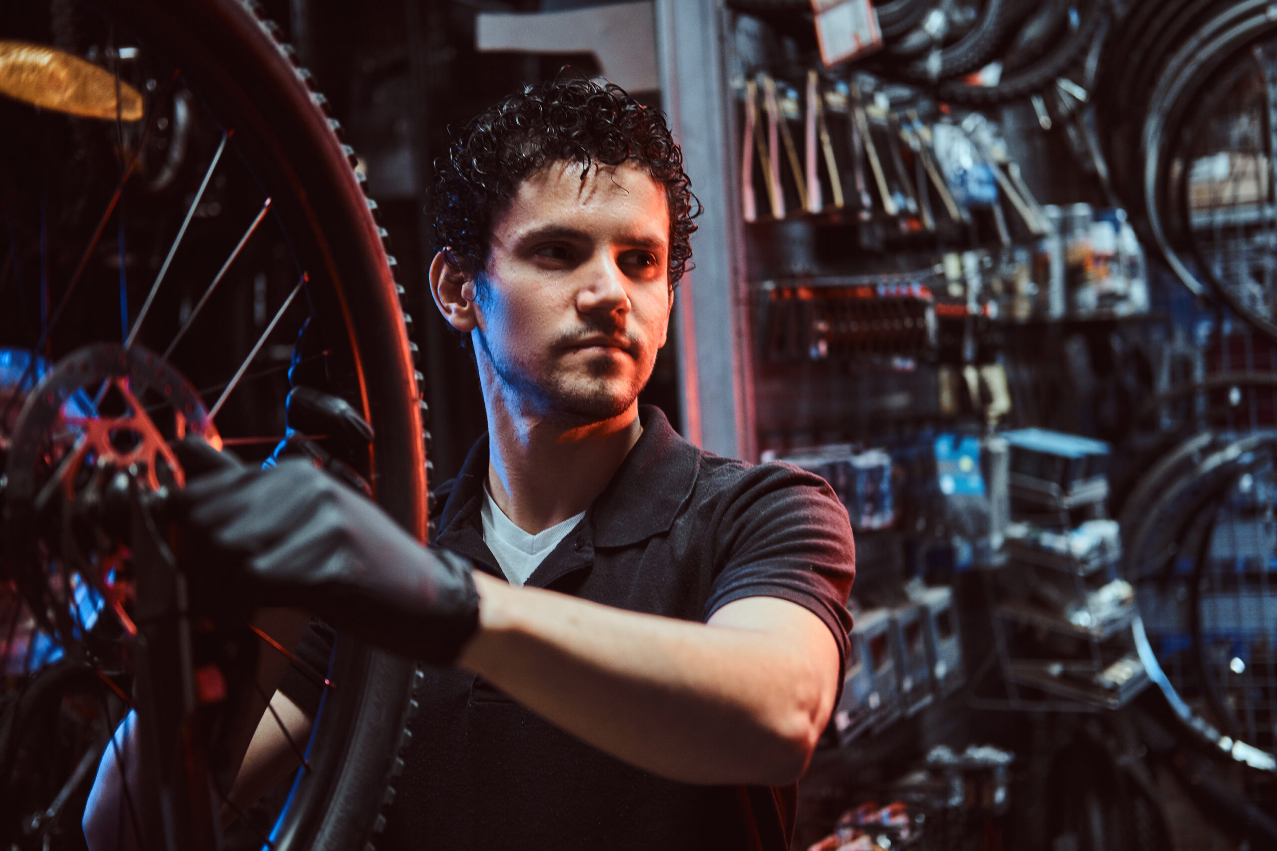 Bicycle mechanic fixing a bike wheel inside a professional repair workshop