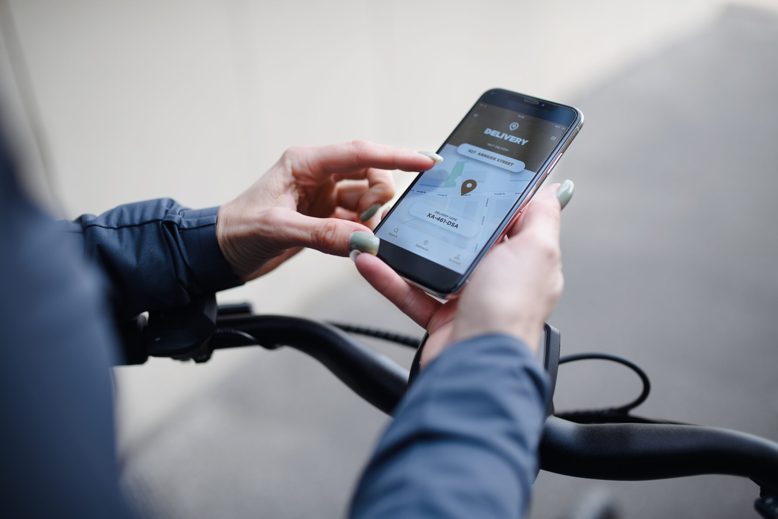 Courier using a smartphone delivery app while riding a bicycle