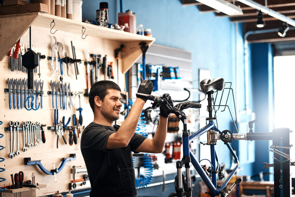 Bicycle mechanic repairing bike in professional workshop