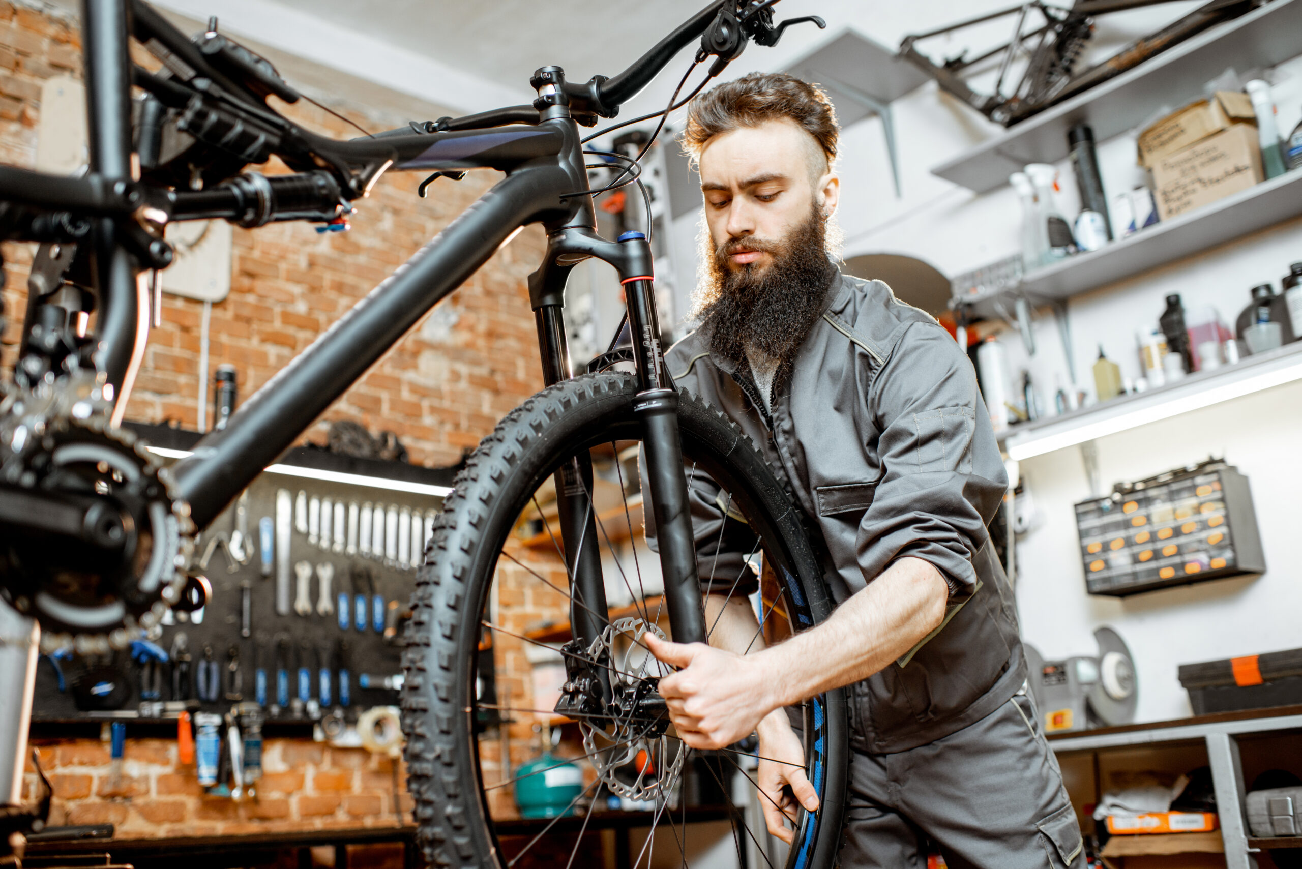 Bicycle mechanic repairing a mountain bike wheel in a workshop