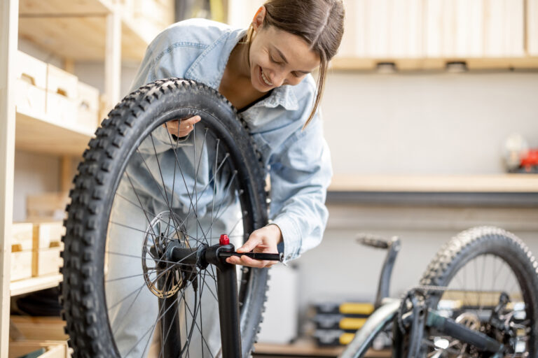 Woman repairing a bicycle wheel in a workshop