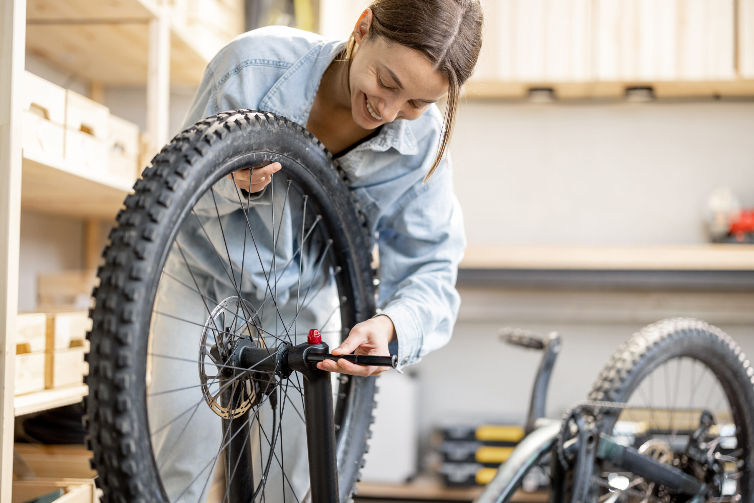 Woman repairing a bicycle wheel in a workshop