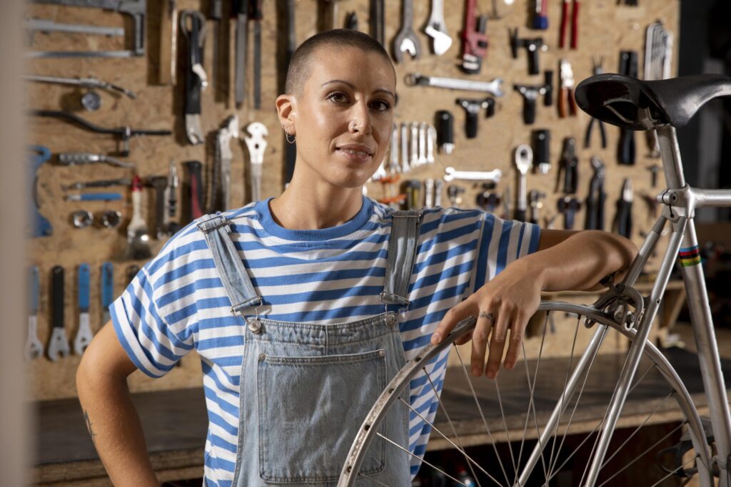 Medium shot of a smiling woman repairing a bicycle
